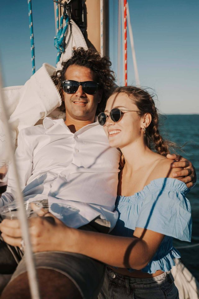 A young couple drinks a glass of wine and relaxes onboard a schooner in Key West