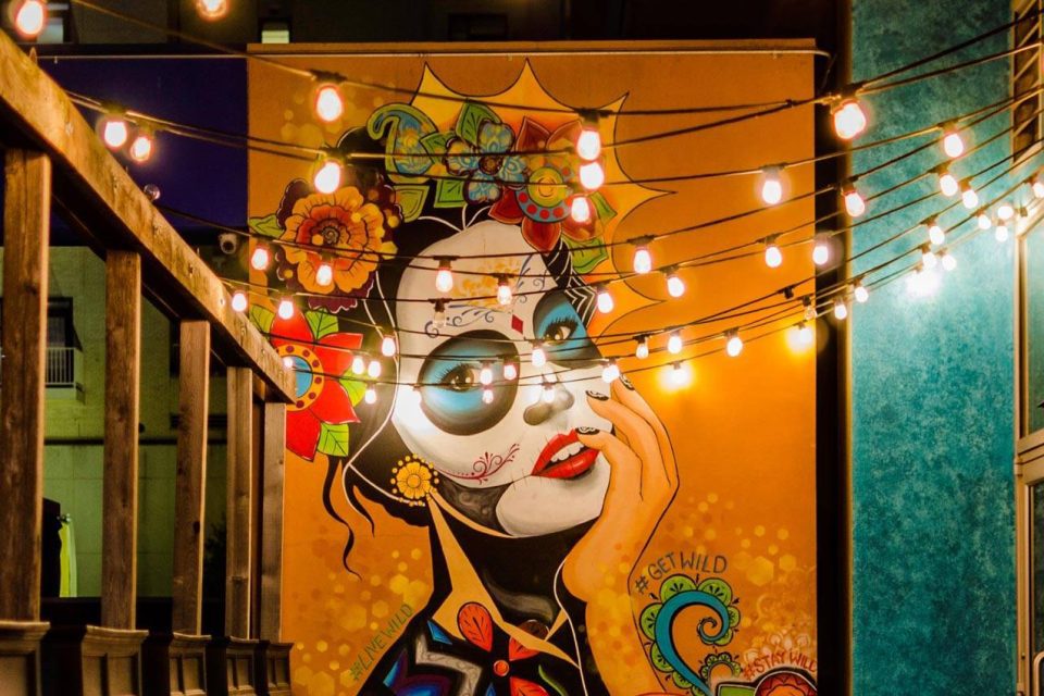 Colorful painting of a Dia de los Muertos Catrina on a wall