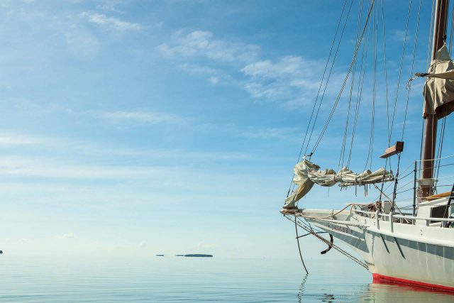 The bow of a Danger Charters schooner sailing in calm waters in Key West