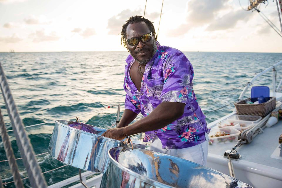 A man in a purple shirt plays steelpan drums during a sailing charter in Key West