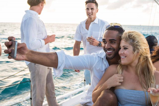 A young couple takes a selfie while enjoying a private sailing charter in Key West with Danger Charters