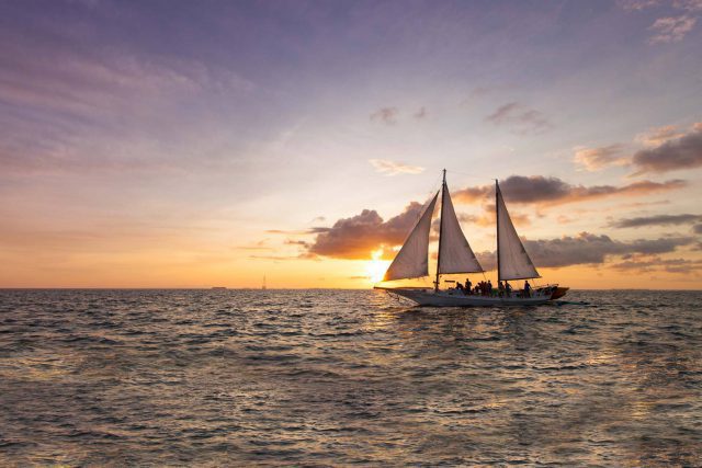 Group aboard a schooner enjoying a sunset cruise in Key West with Danger Charters