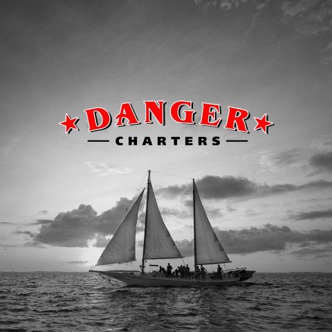 Danger Charters of Key West logo above a schooner in black and white
