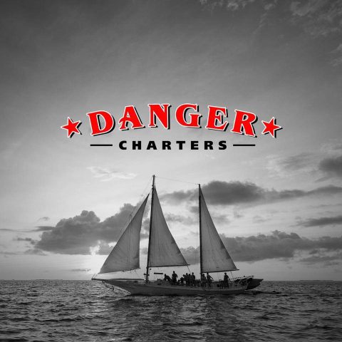 Danger Charters of Key West logo above a schooner in black and white