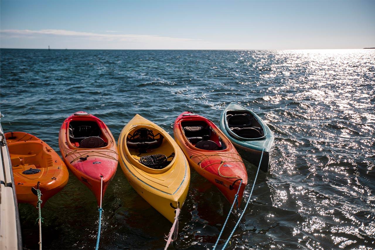 Five colorful kayaks float in the water off the coast of Key West, FL