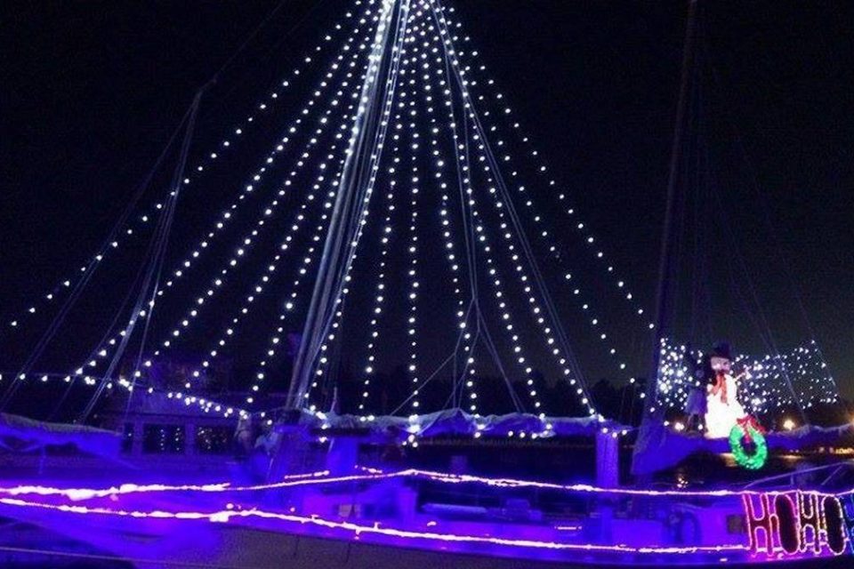 A boat illuminated by Christmas lights at night during the Key West holiday boat parade