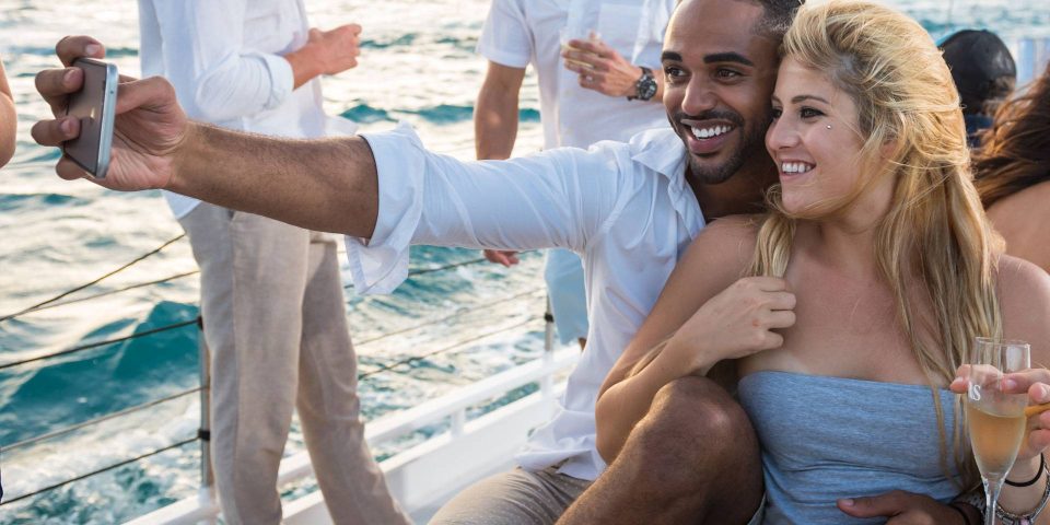 A young couple takes a selfie while enjoying a private sailing charter in Key West with Danger Charters