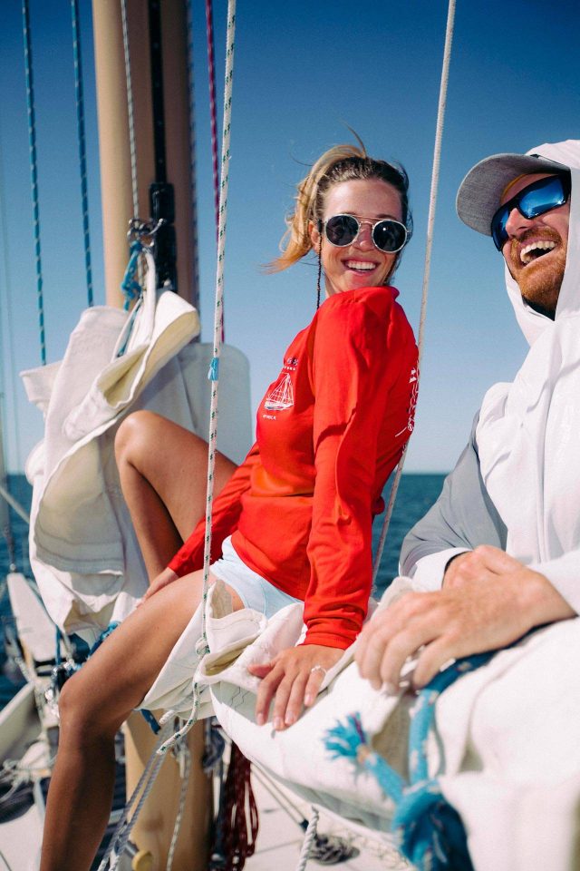 Young woman and man smiling and laughing in the sun while sailing on a schooner in Key West