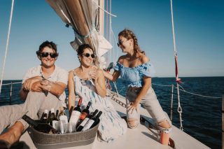 Friends enjoy a glass of white wine while on a sailing charter with Danger Charters in Key West, FL