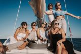 A group of young friends relax in the sun while on a sailing charter with Danger Charters in Key West, FL