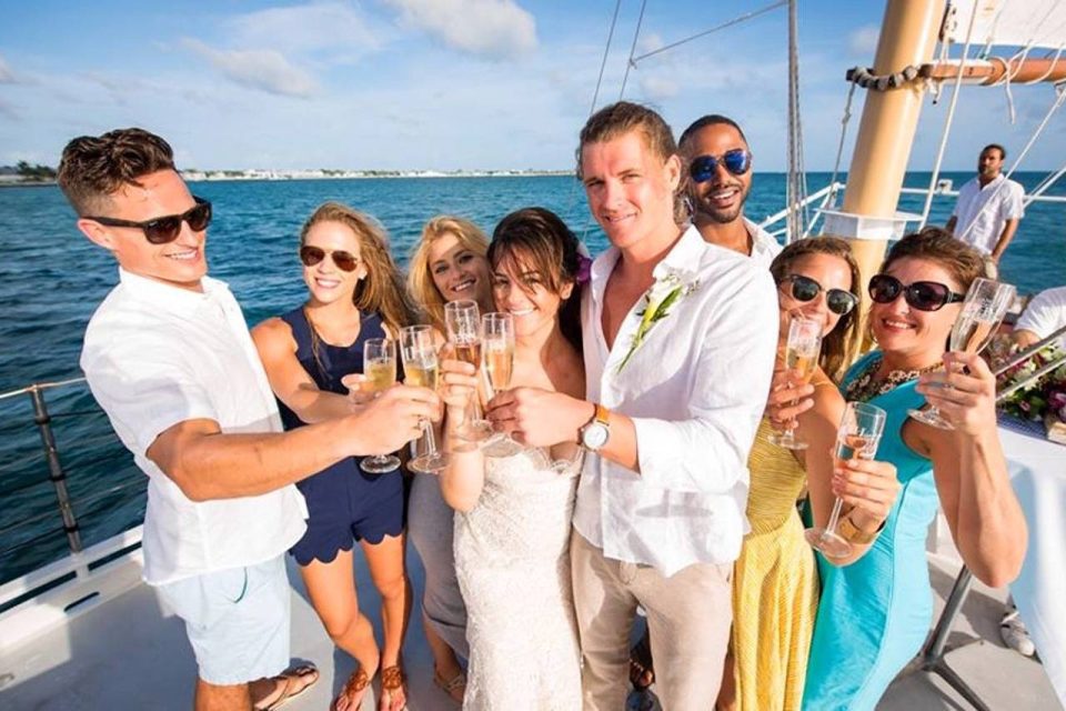 A young couple drinks champagne and enjoys a sailboat wedding with friends in Key West