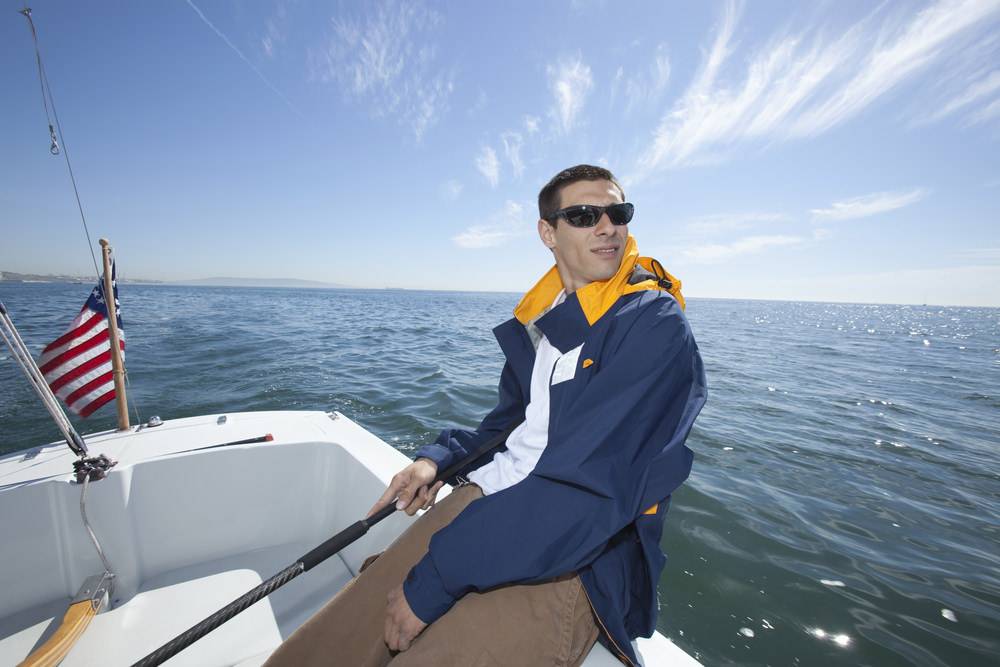 Young man on a boat in a windbreaker